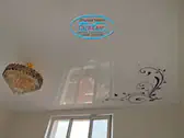 Опънат таван в спалня с Флорален мотив в ъгъла.