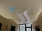 Опънат таван с диодно осветление на вълни в коридор в хотел.