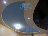 Син опънат таван с обли форми, с полилей в офис.
