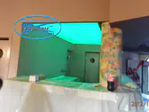 Светещ опънат таван над бар с RGB LED осветление включено на зелено.